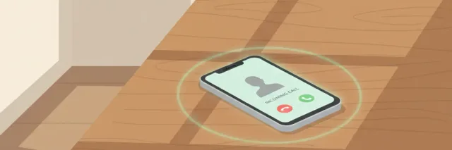 A single smartphone resting face-up on a wooden kitchen table, screen showing only a blank incoming call, no caller ID, no people in the frame.